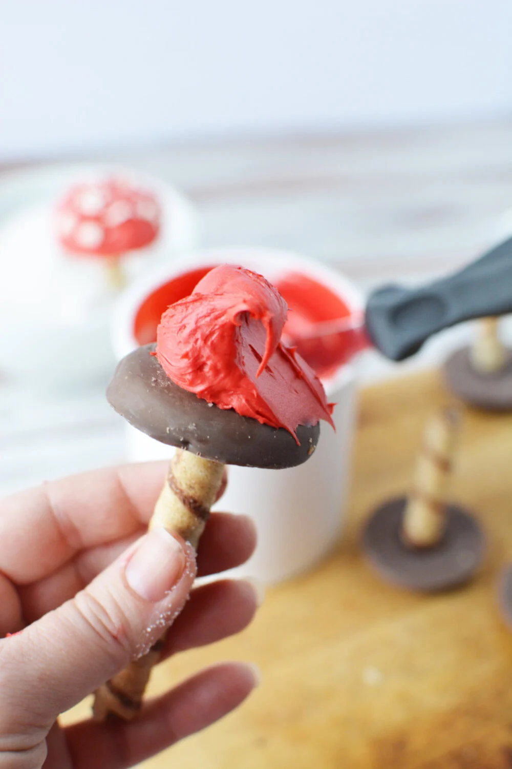 Frosting a cookie with red frosting. 