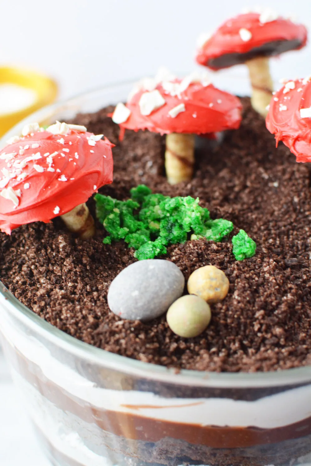 Candy rocks, edible moss, and cookie mushrooms on a trifle. 