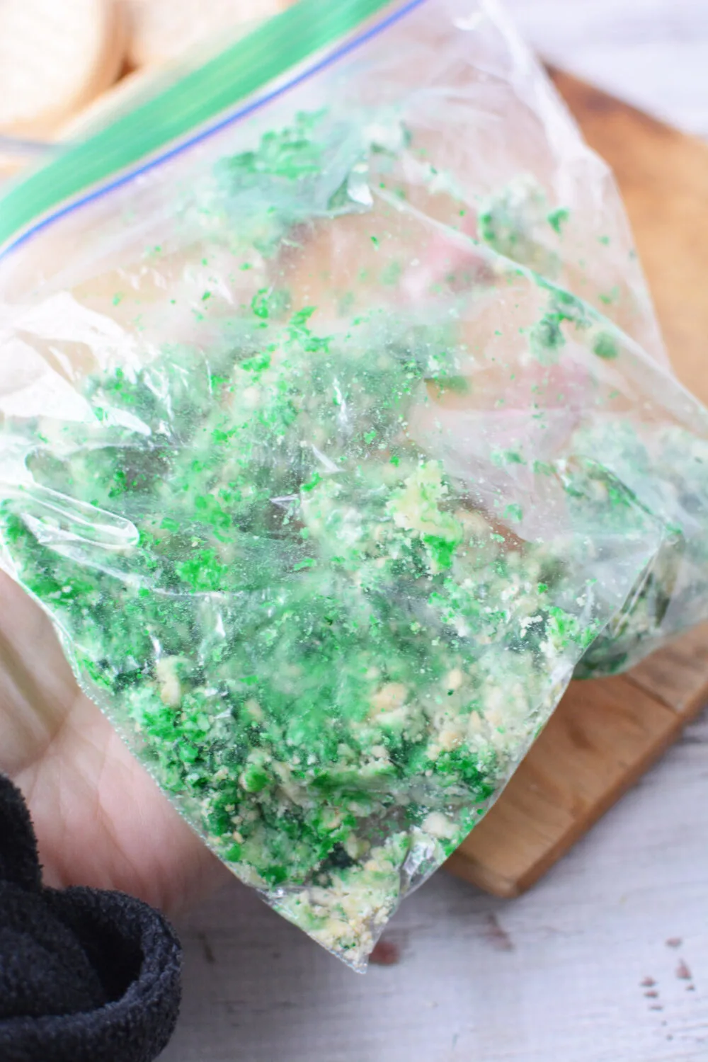 Crushed cookies and green food coloring in a sandwich bag. 