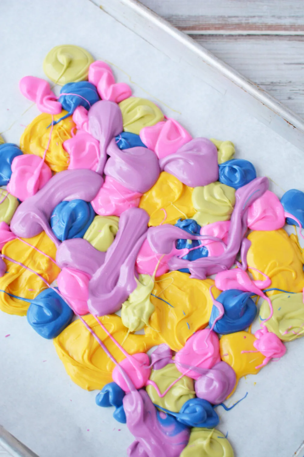 Blobs of candy melts on a baking sheet. 