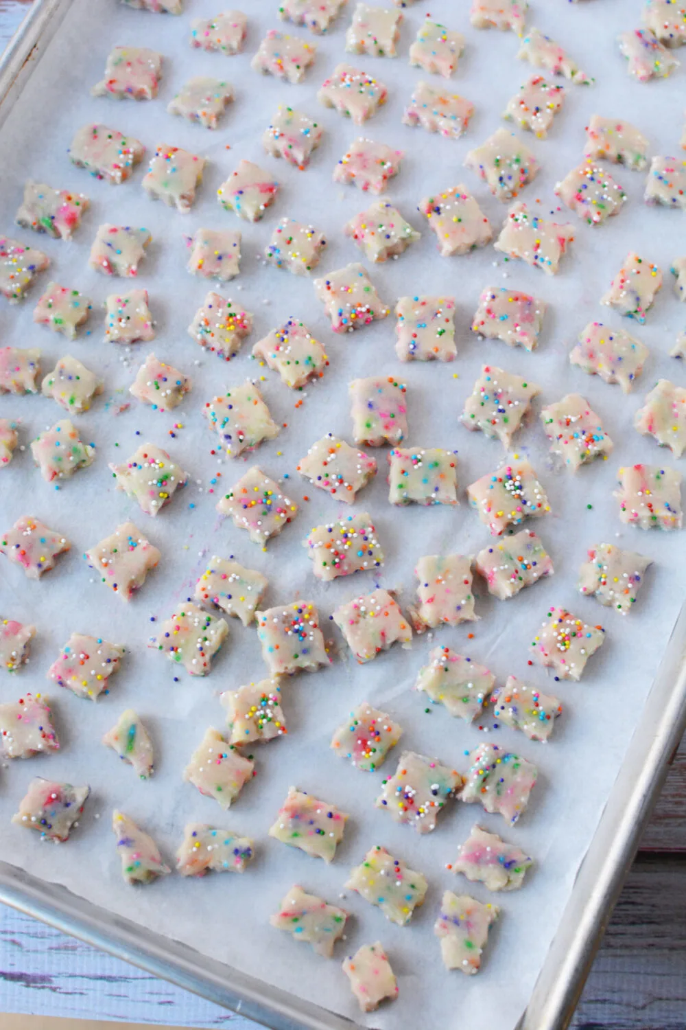 Tiny squares of cookie dough on a baking sheet. 