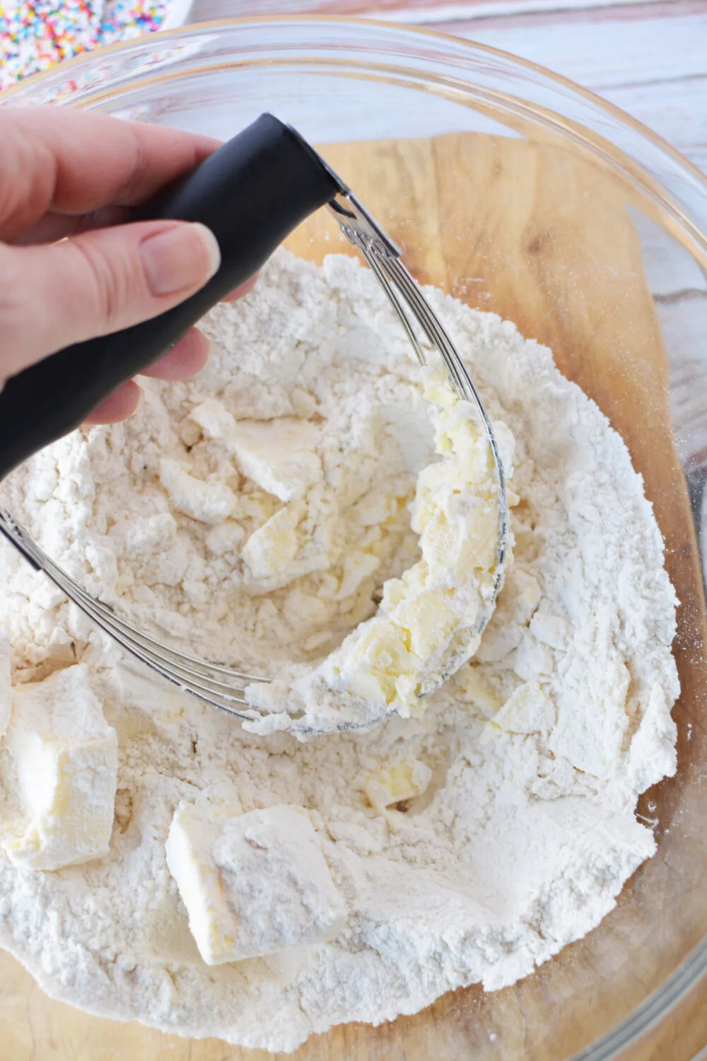 Using a pastry blender to combine butter and flour mixture. 
