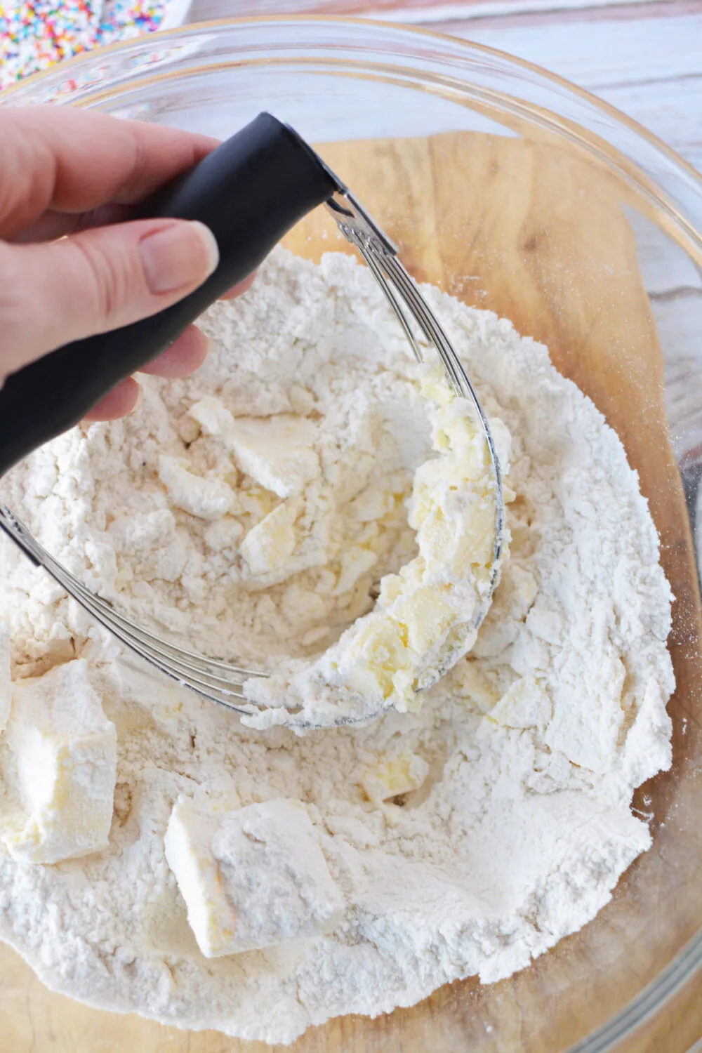 Using a pastry blender to combine butter and flour mixture.