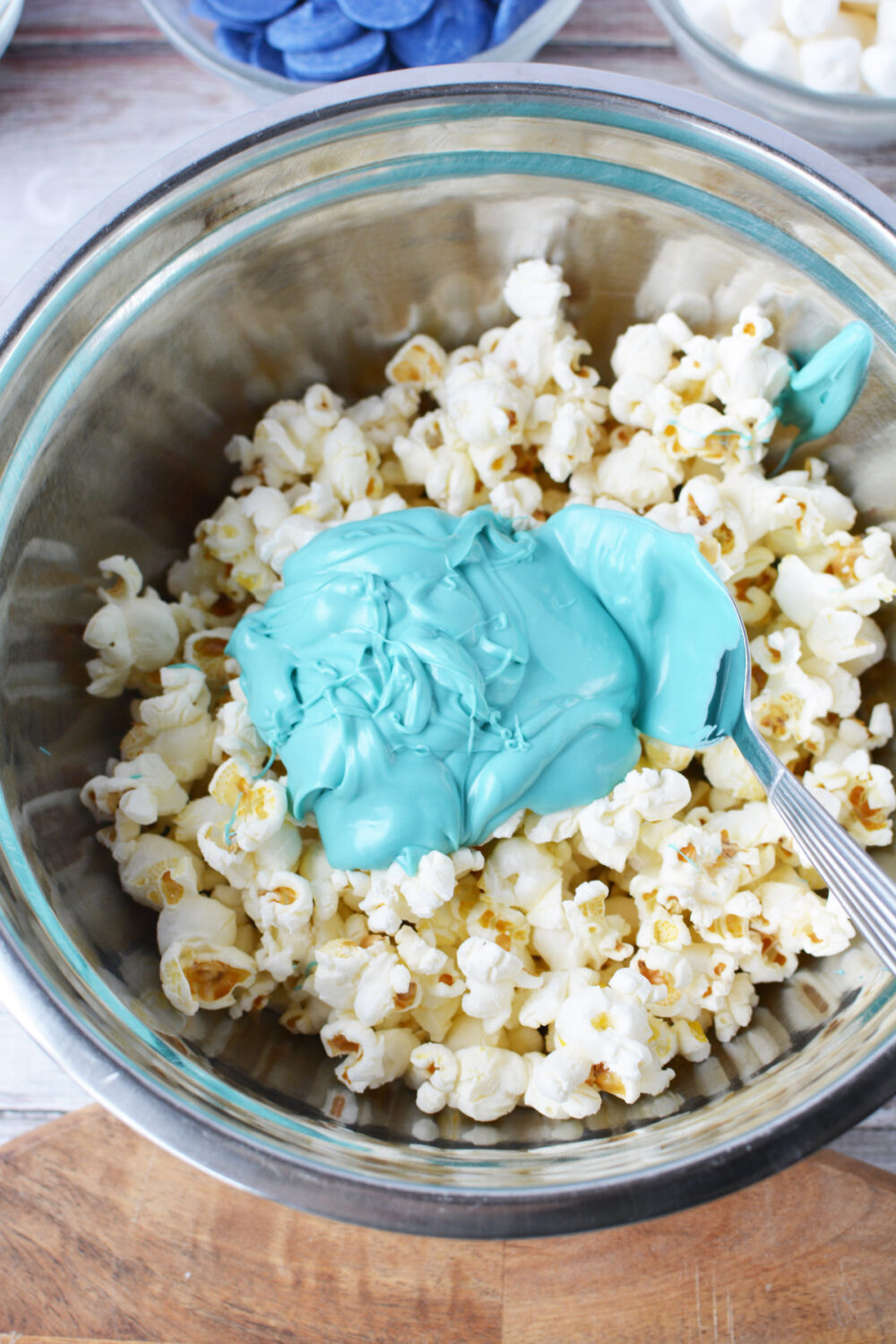 Blue melted candy in a bowl with plain popcorn.
