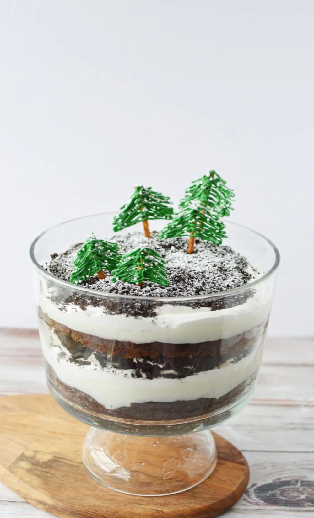 Chocolate winter trifle with green trees on top.