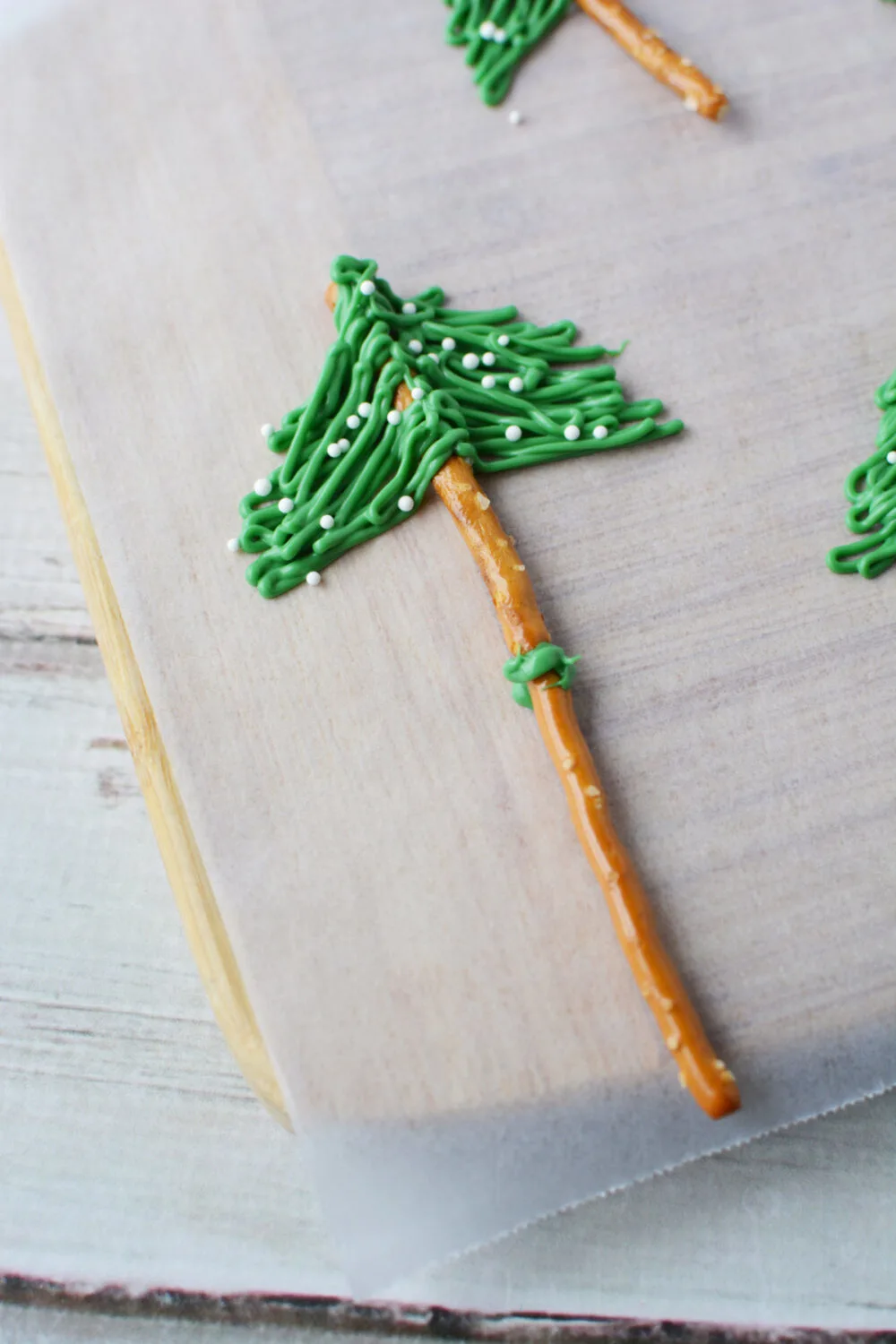 Pretzels and green candy melt to make an edible evergreen tree. 