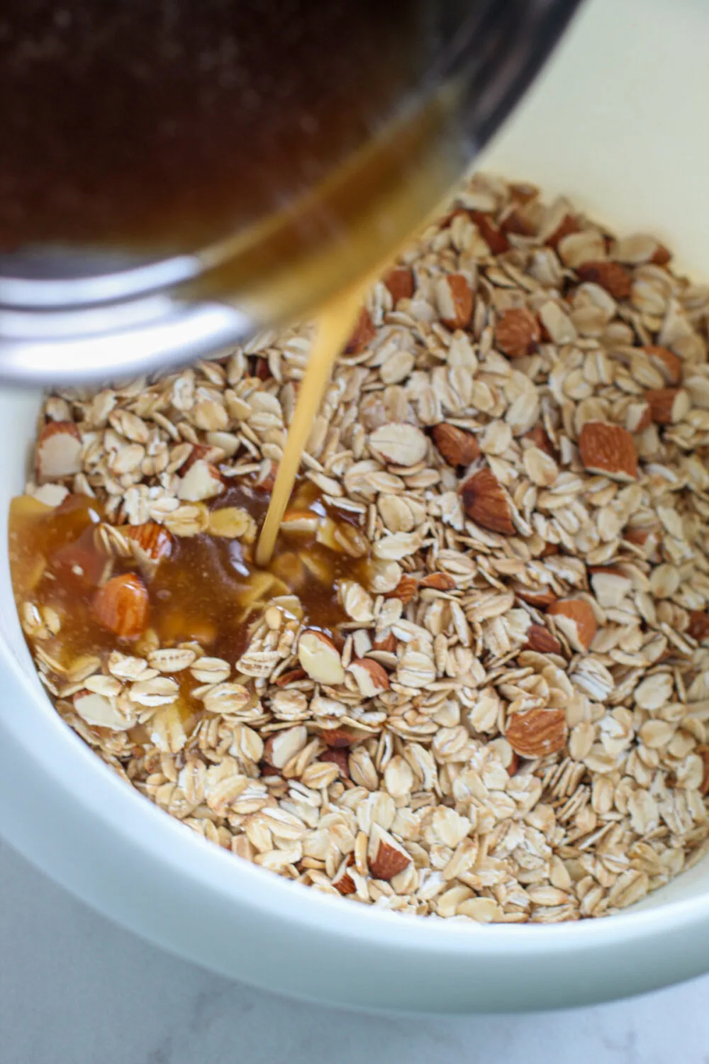 Pouring melted brown sugar on top of oats. 