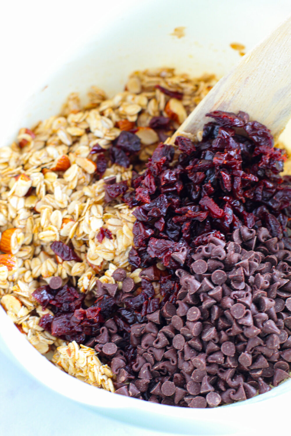 Mixing cherries and chips into granola bar mixture. 
