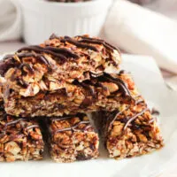 Stacked granola bars with chocolate drizzle.
