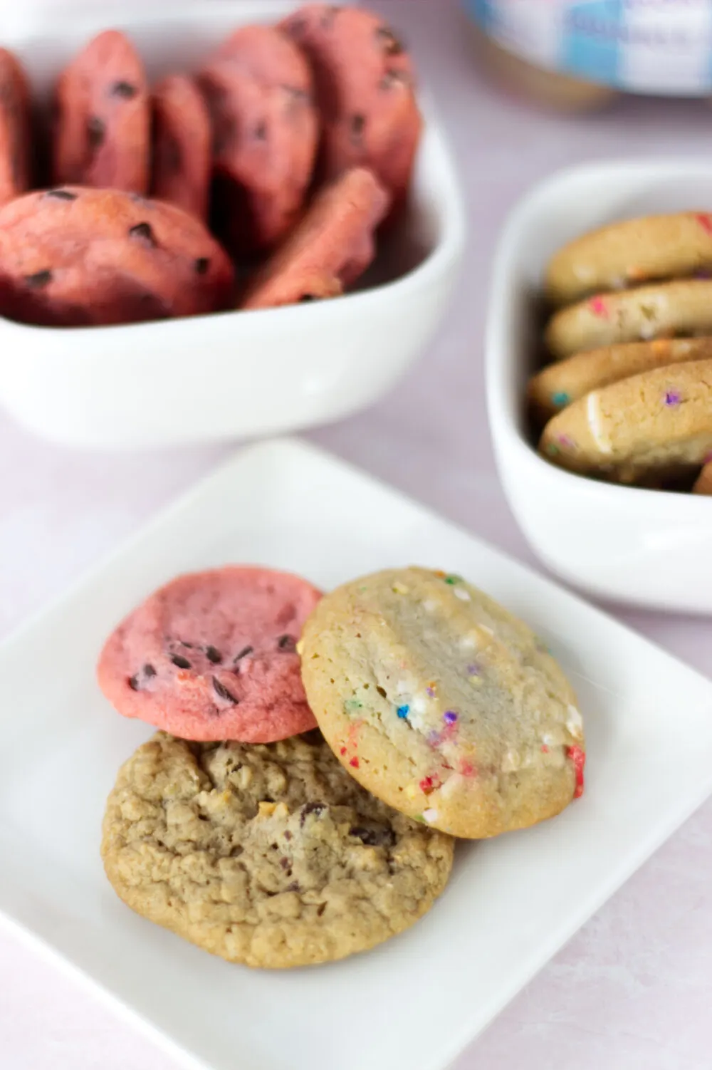 Cherry, oatmeal, and sprinkle sundae cookies on a plate. 