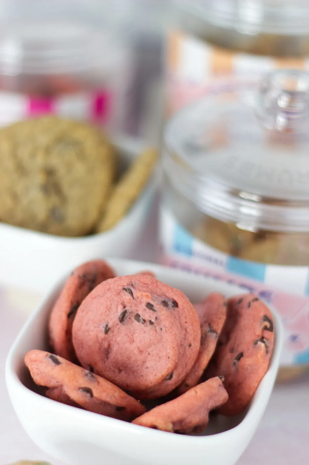 Cherry chocolate cookies in a bowl next to other cookies. 