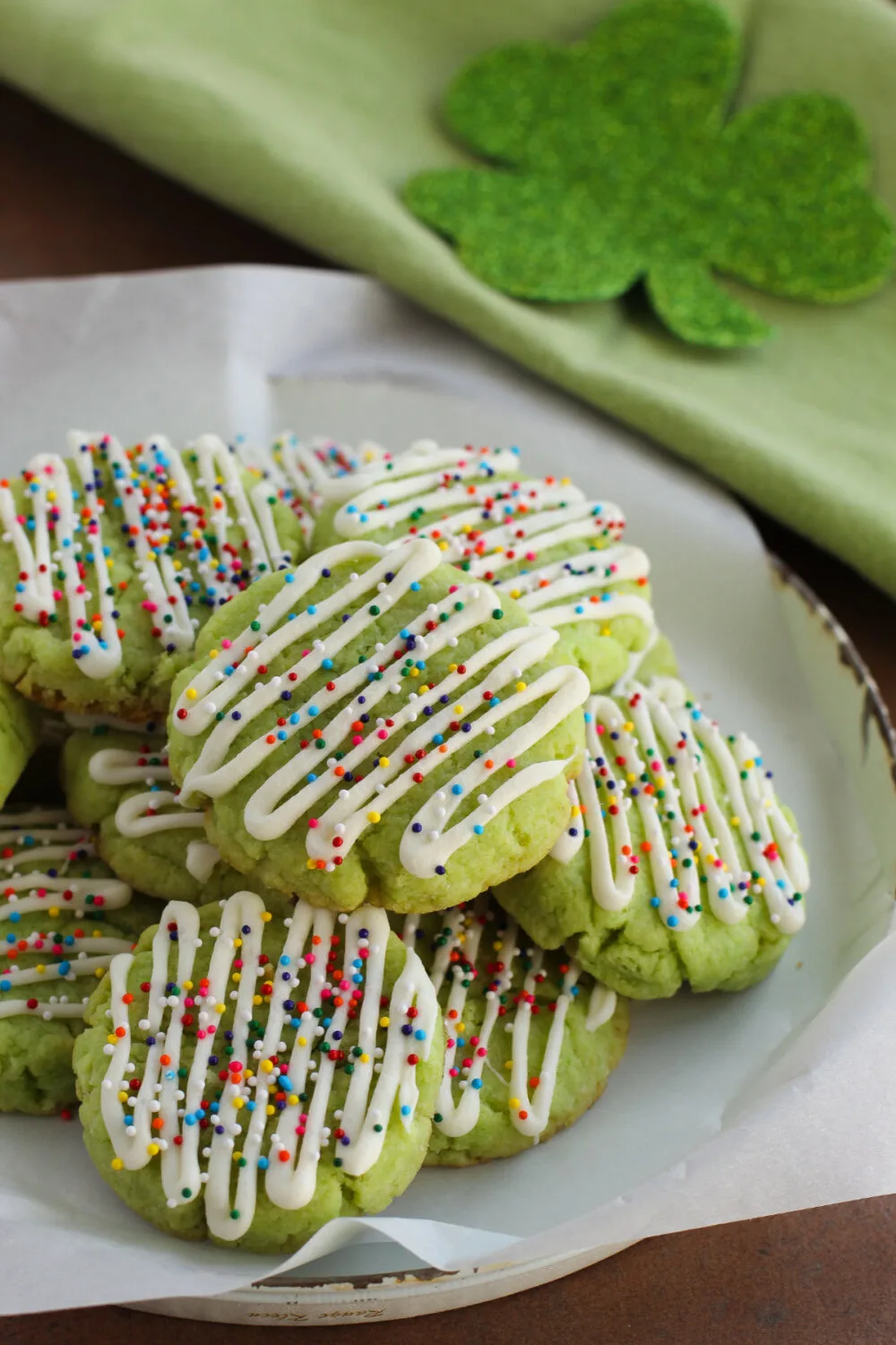 Pile of green cake mix cookies on a plate. 