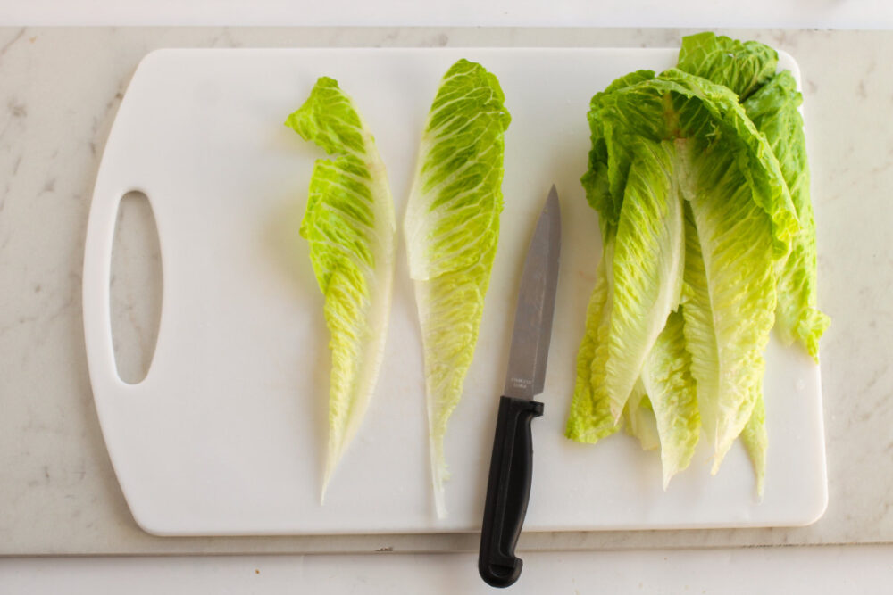 Cutting romaine lettuce on a board. 