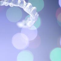 Clear aligners with a purple background.