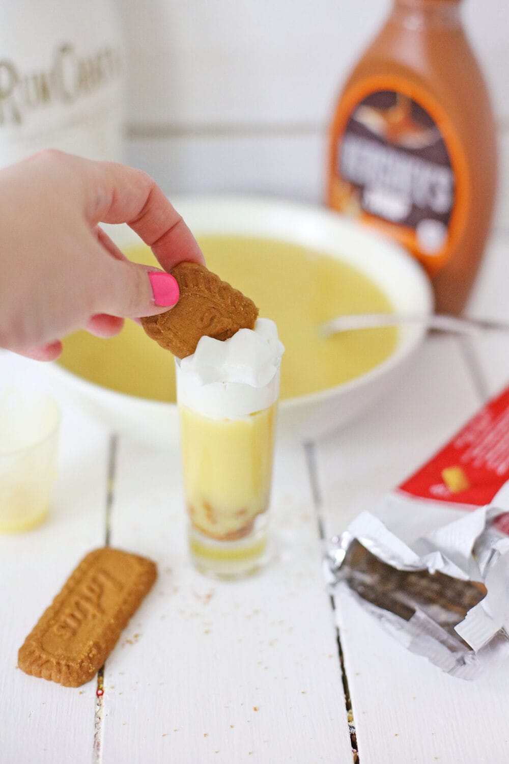 Adding 1/2 of a Biscoff cookie to the top of a RumChata pudding shot. 