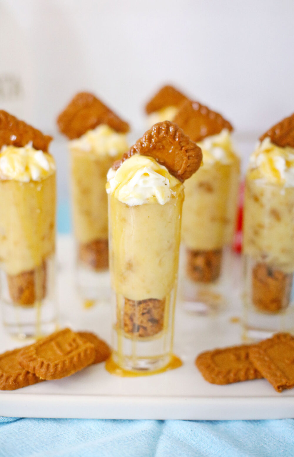 Cookie pudding shots on a tray with more Biscoff cookies. 