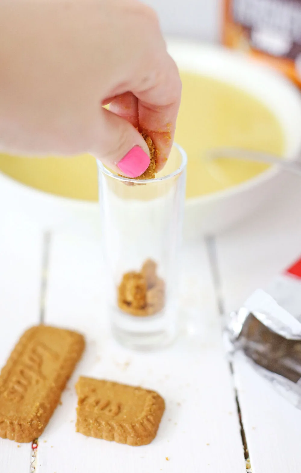 Adding cookie crumbs to a shot glass. 