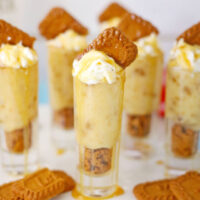 Cookie pudding shots on a tray with more Biscoff cookies.