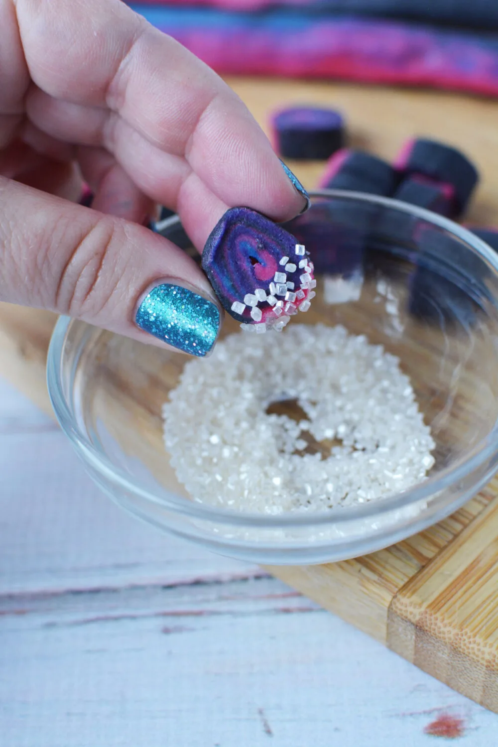 Dipping mini cookie into sugar sprinkles. 