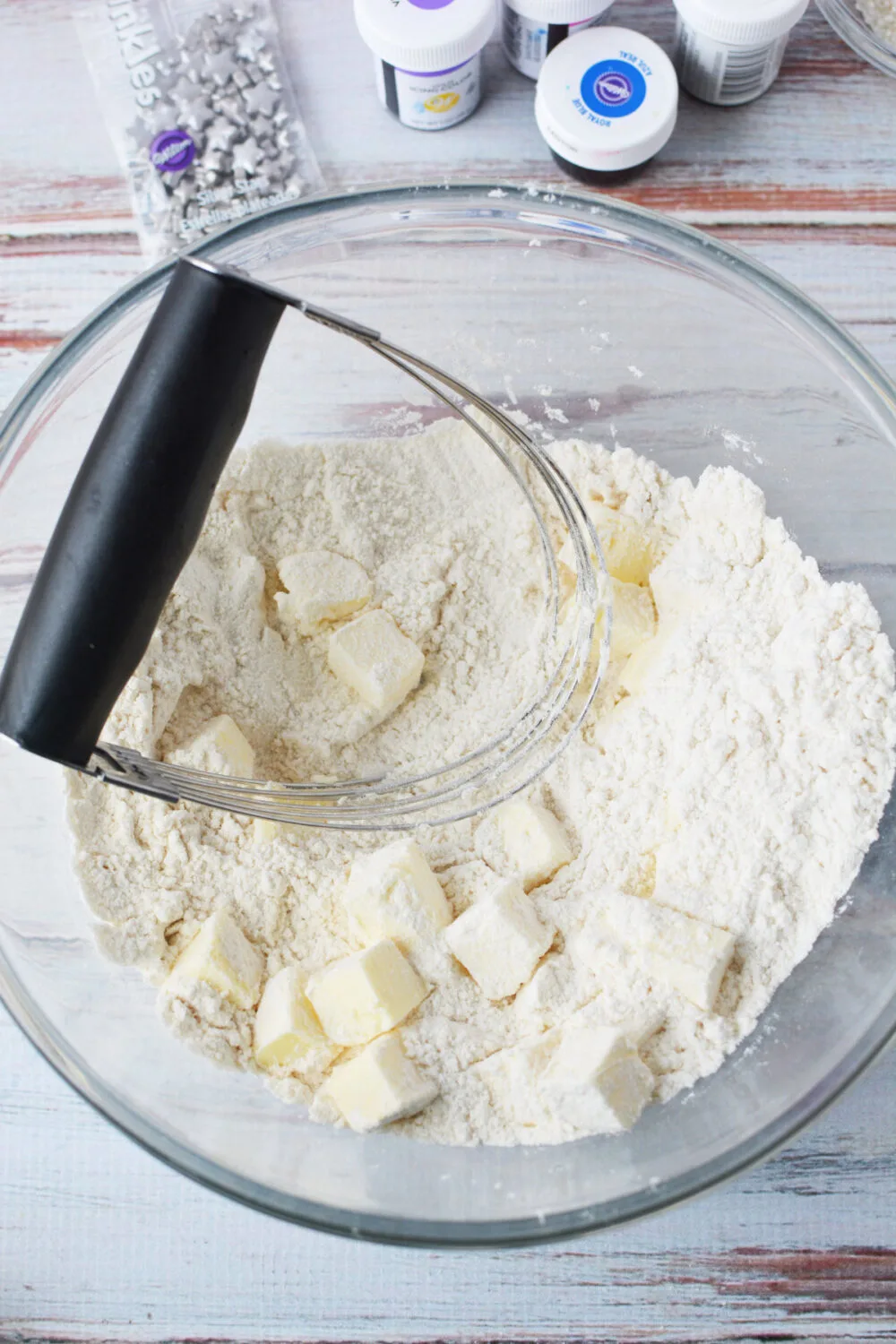 Pastry blender in the bowl with cubed butter and flour mixture. 