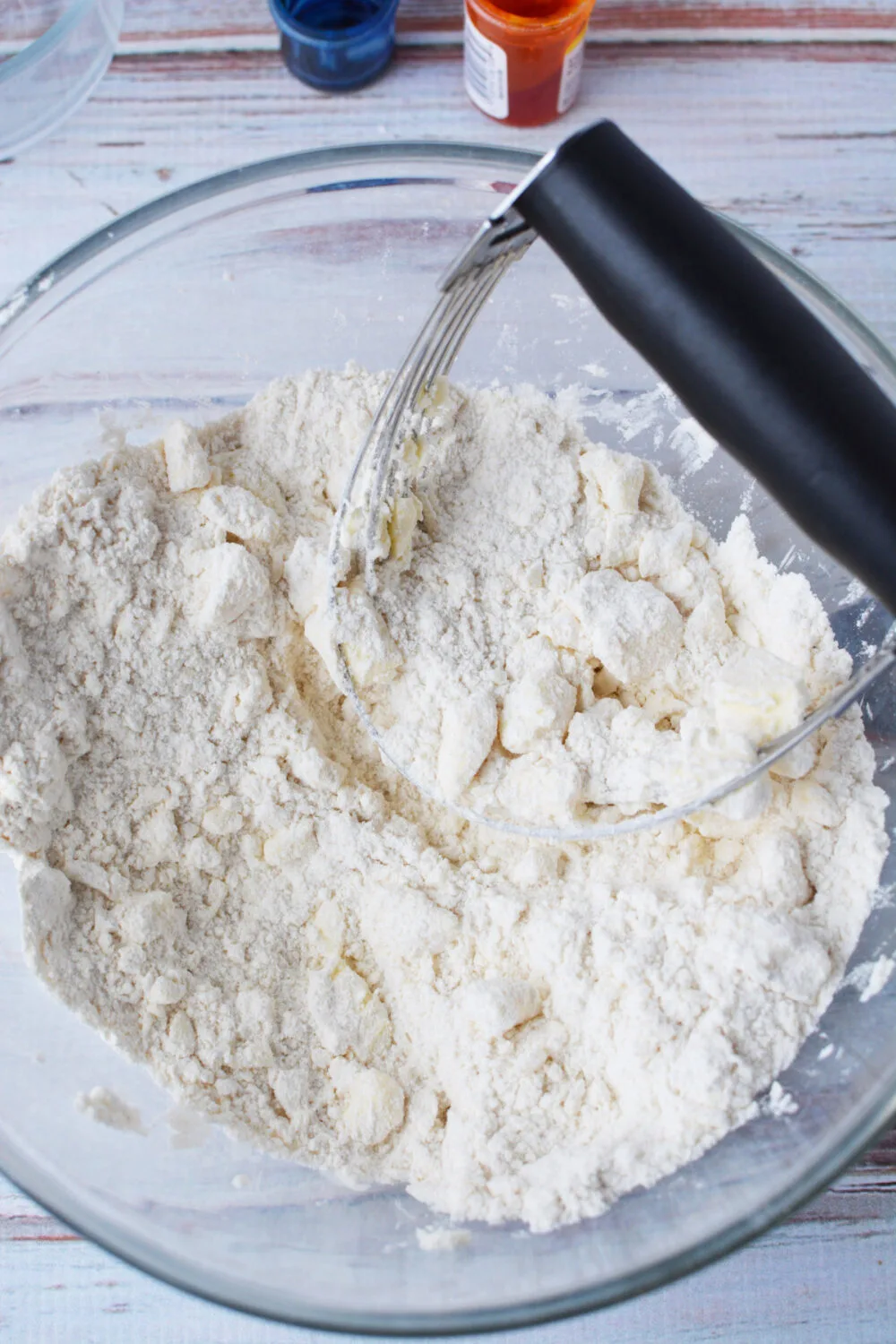 Using a pastry blender to cut butter into flour mixture. 