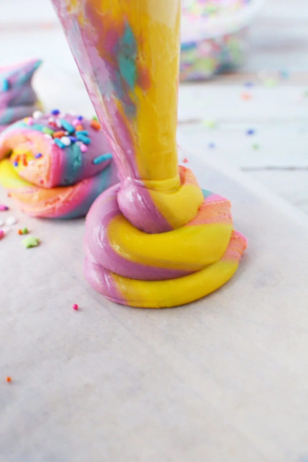 Piping unicorn poop fudge onto wax paper.