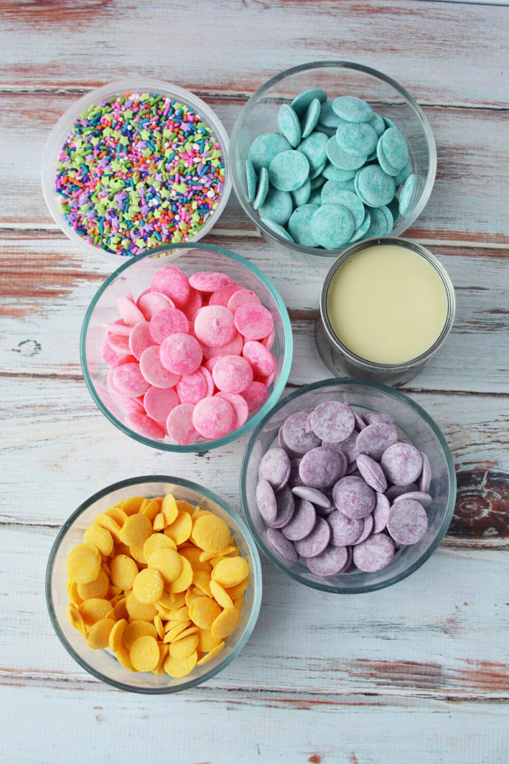Candy melts, sprinkles, and sweetened condensed milk in bowls. 