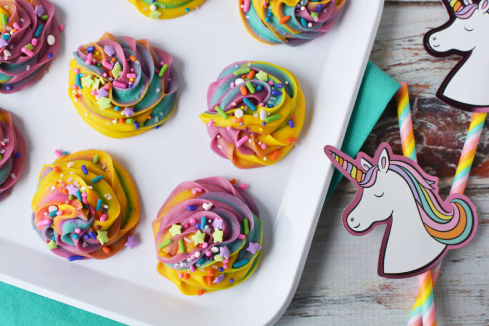 Unicorn poop fudge on a plate next to unicorn party favors. 