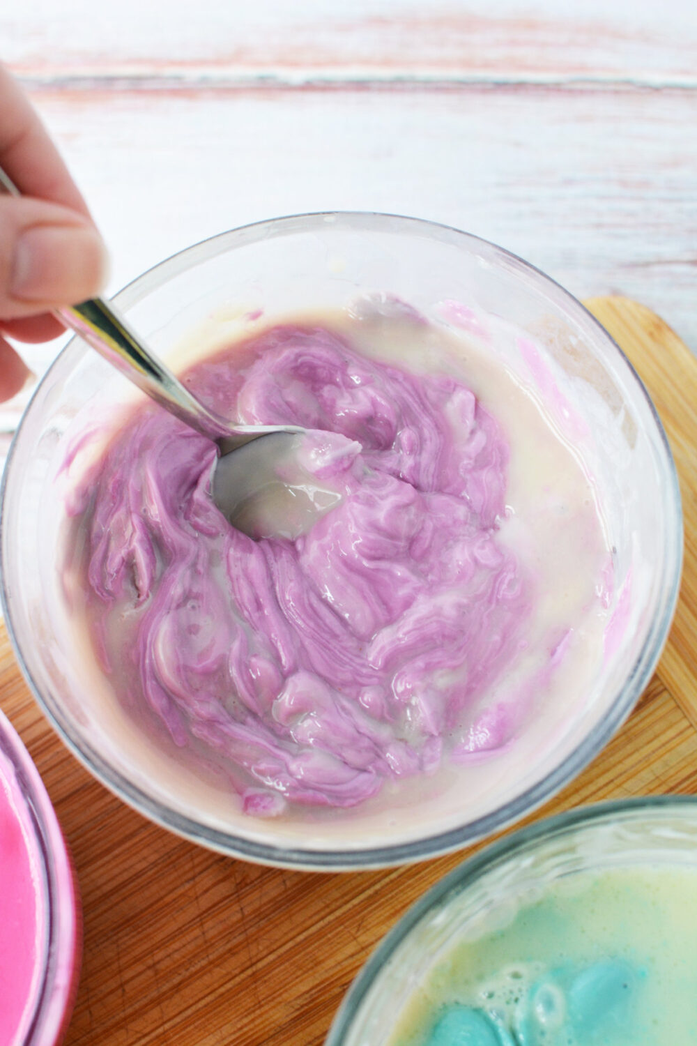 Stirring purple candy melts with sweetened condensed milk. 