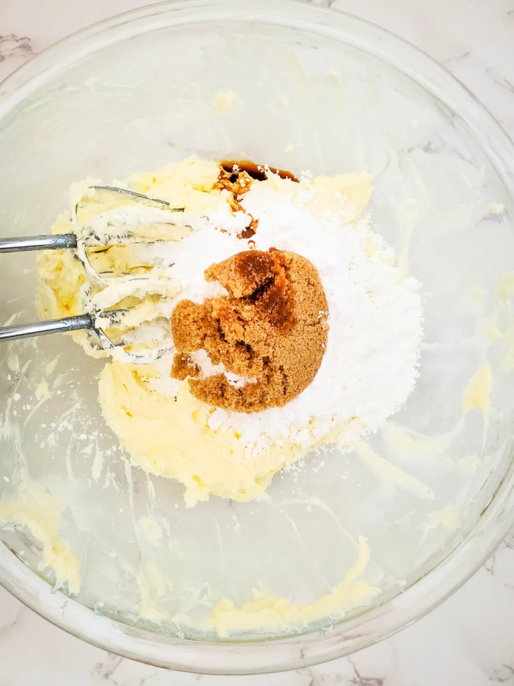 Brown sugar, butter, and cream cheese in a mixing bowl. 