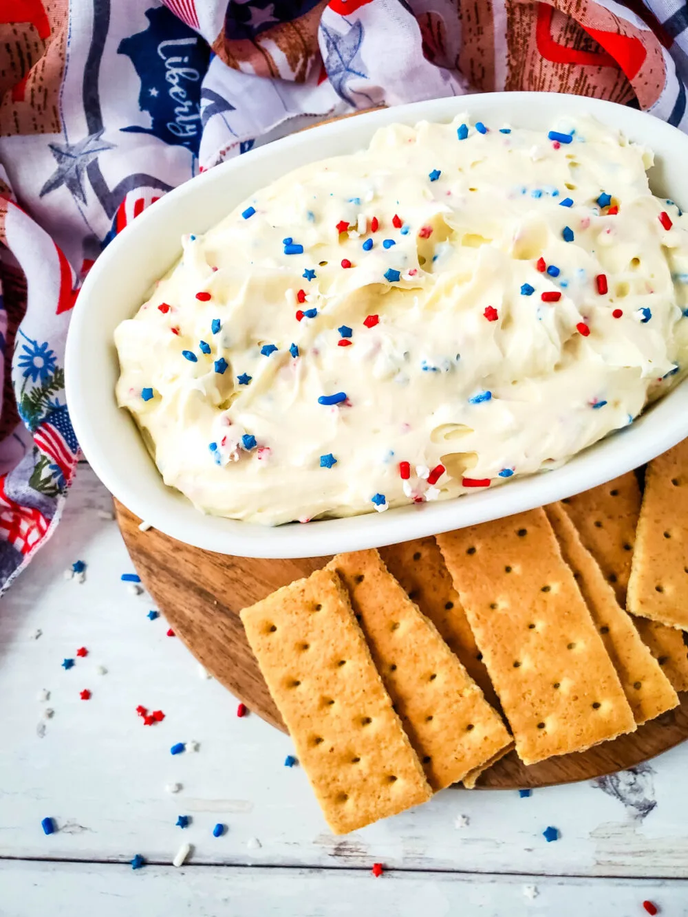 Cheesecake dip with red, white, and blue sprinkles, and graham crackers for dipping. 