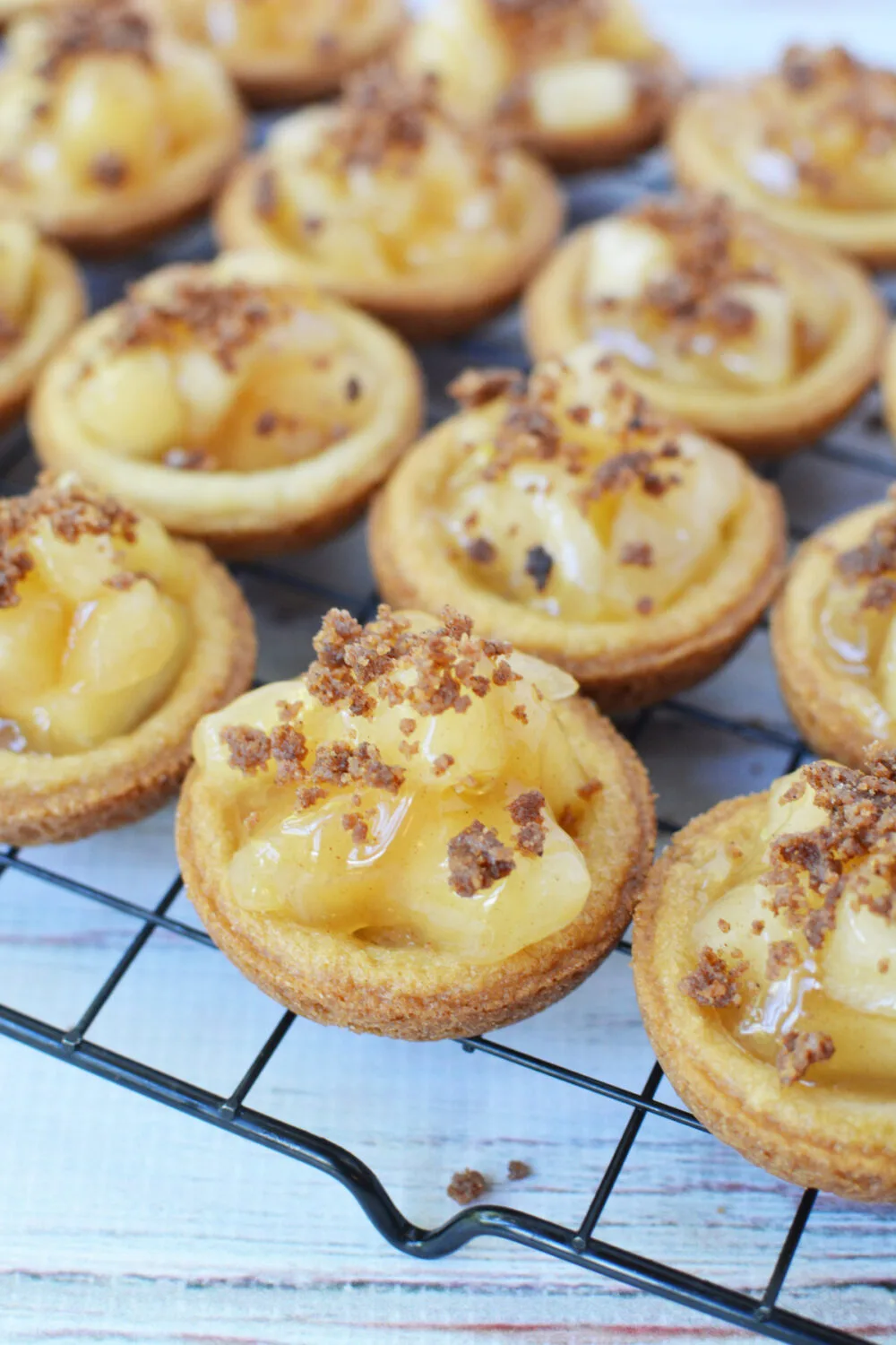 Apple pie cookies with a brown sugar crumble topping on a rack. 