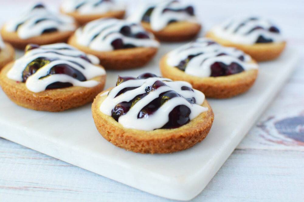 Blueberry pie cookies with glaze on a tray. 