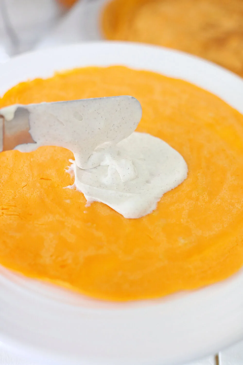 Spreading filling onto a pumpkin crepe. 