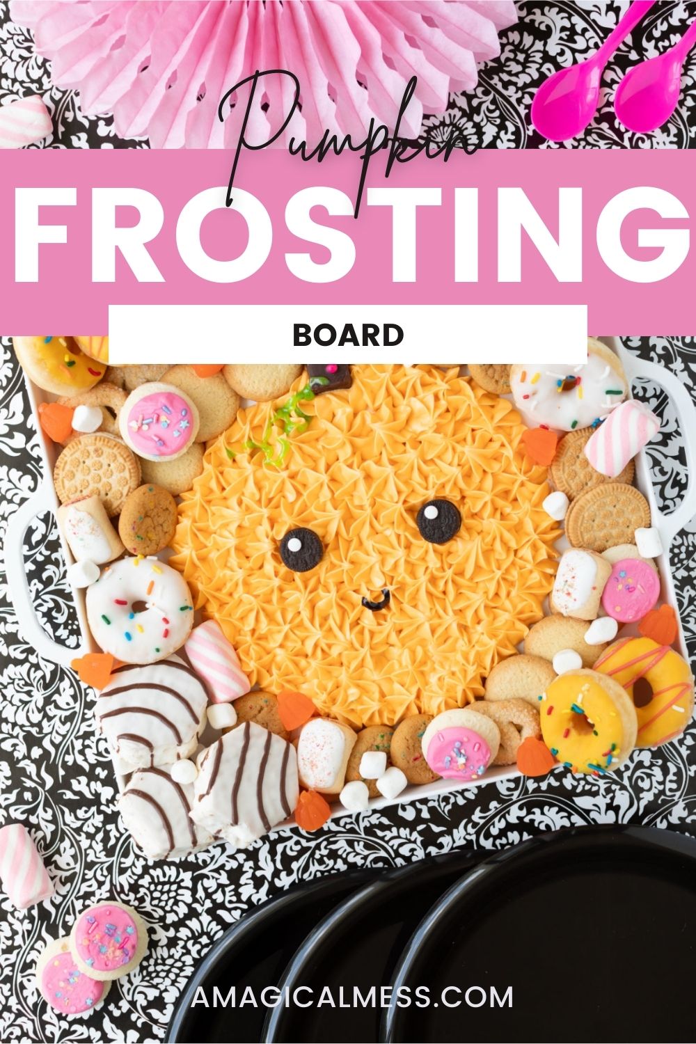Cute frosting pumpkin on a board with a variety of sweets and treats.