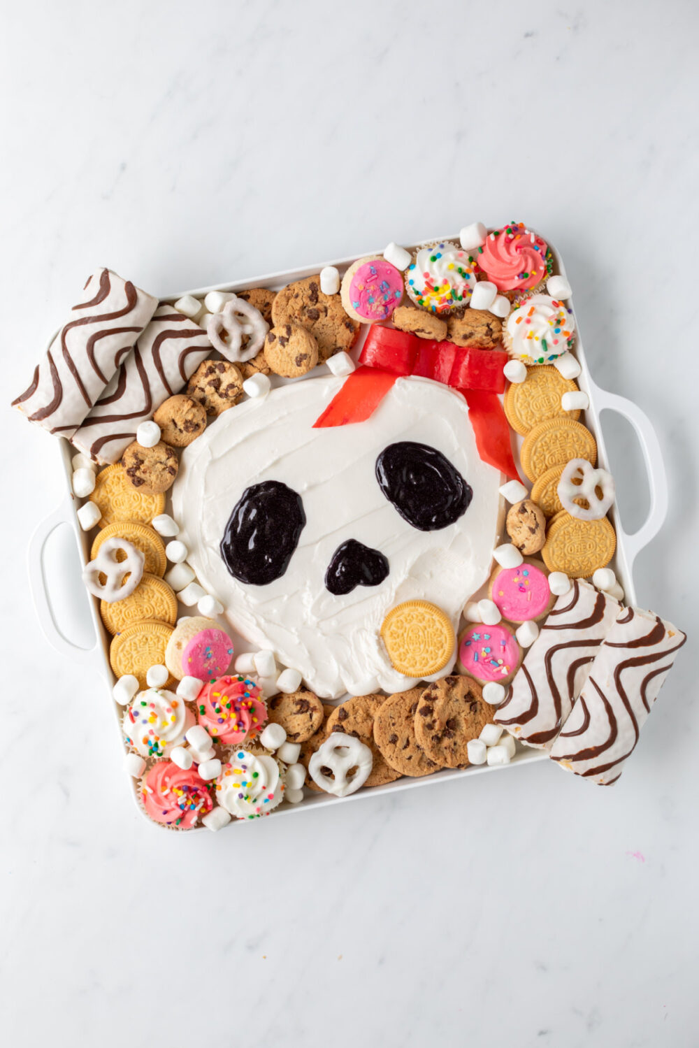 Cookie being dipped into frosting skull. 