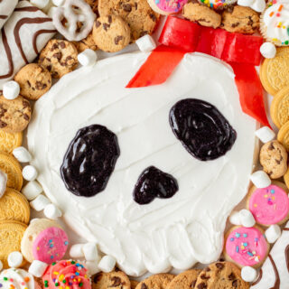 Skull frosting board surrounded by cookies and candies.