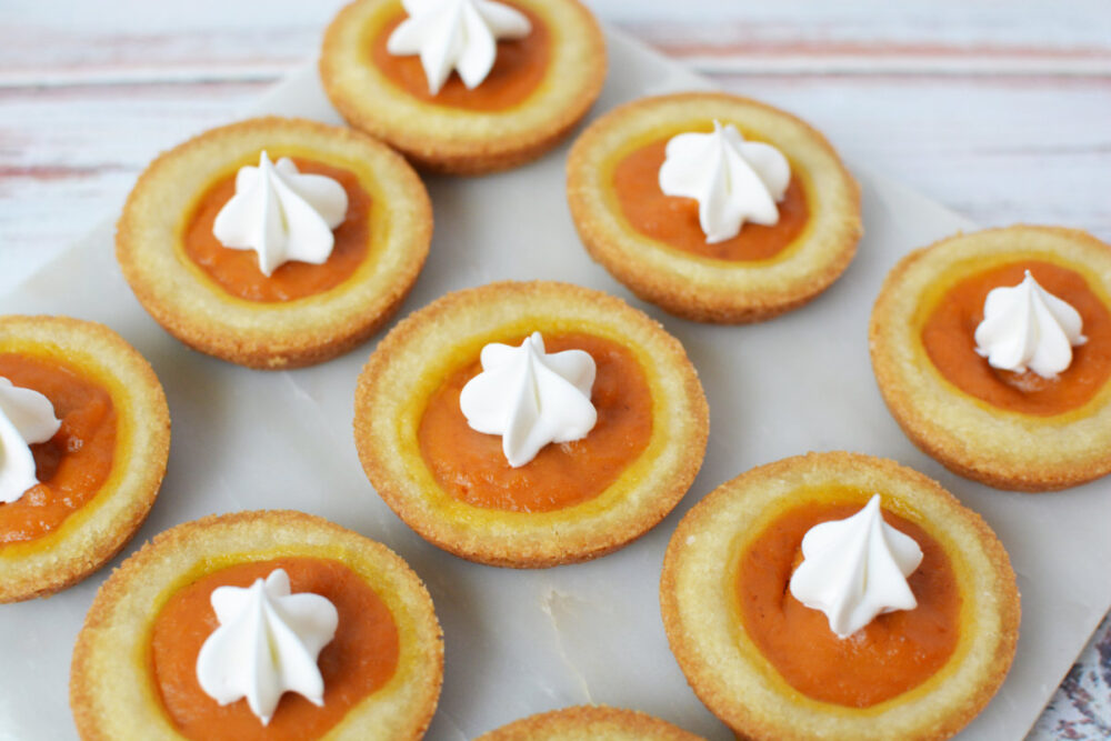Pumpkin pie cookies with whipped cream toppings.