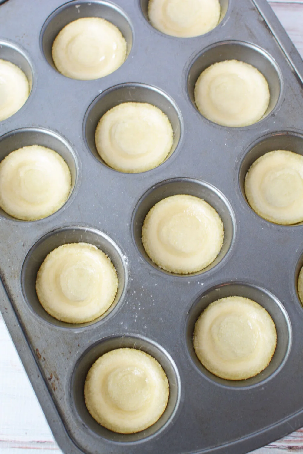 Cookie dough crusts in a muffin pan.
