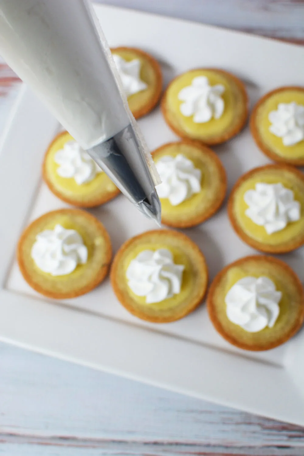 Piping whipped topping onto key lime pie cookies. 