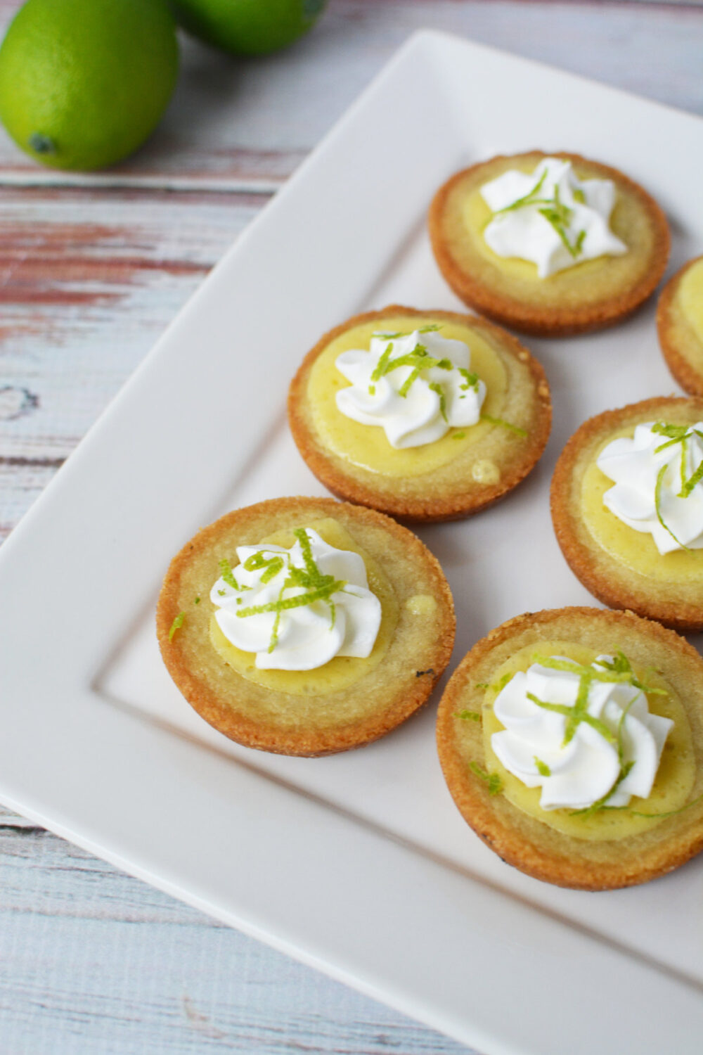 Key lime pie cookies with whipped cream and lime zest on top. 