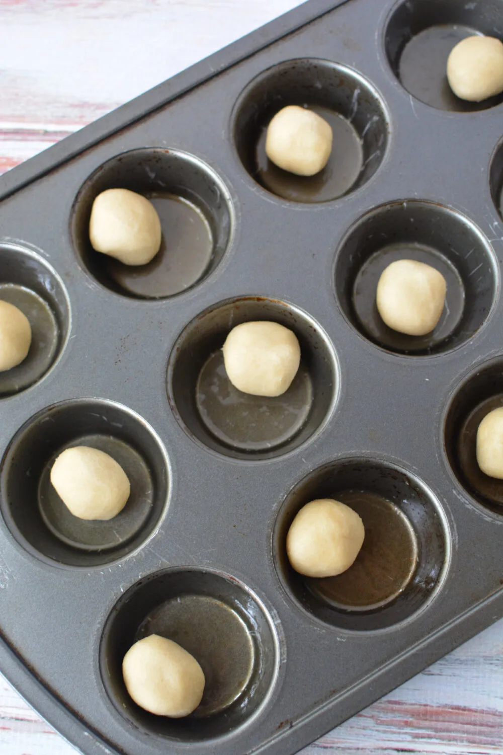 Cookie dough balls in a muffin tin. 