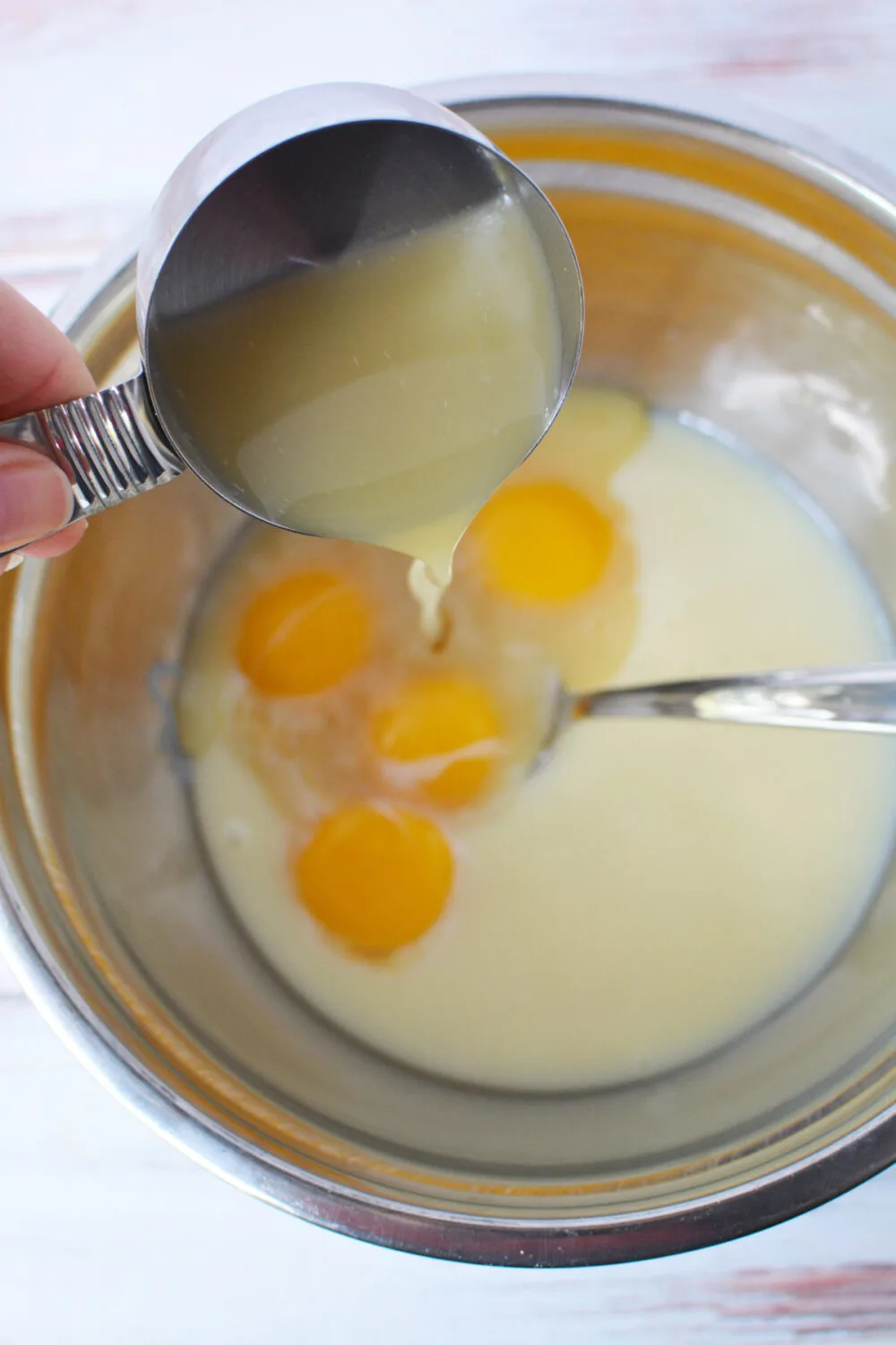 Egg yolks in sweetened condensed milk in a bowl. 