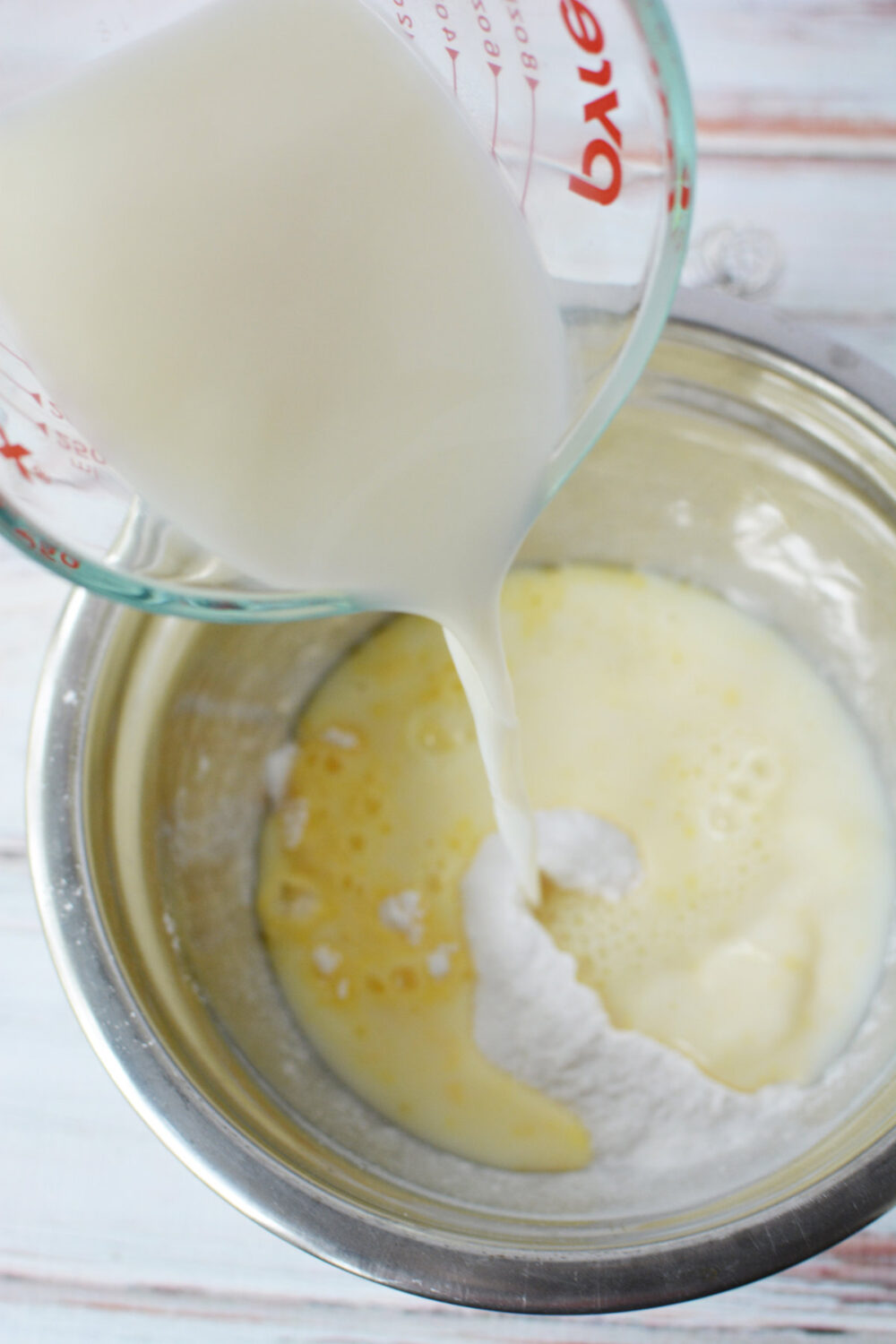 Pouring milk into instant pudding mix. 