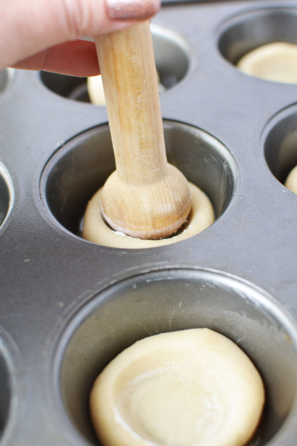 Pressing tart shaper into cookie dough. 
