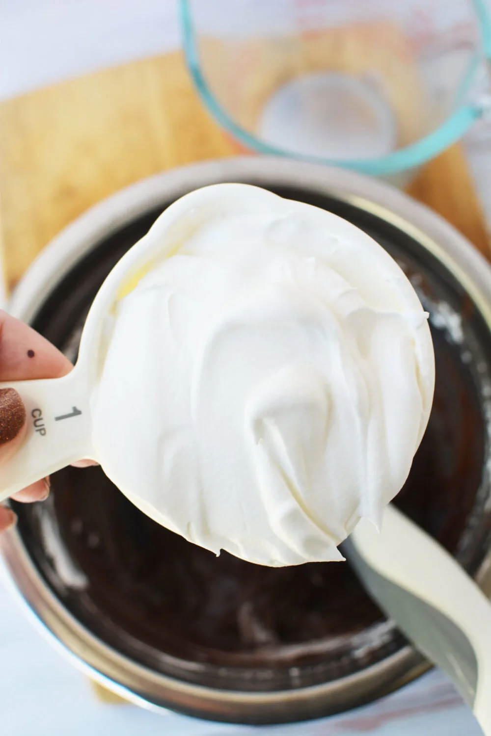 Adding whipped topping into chocolate pudding. 