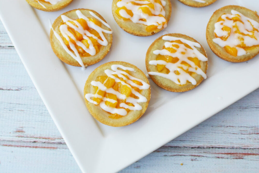 Peach pie cookies topped with glaze on a tray. 