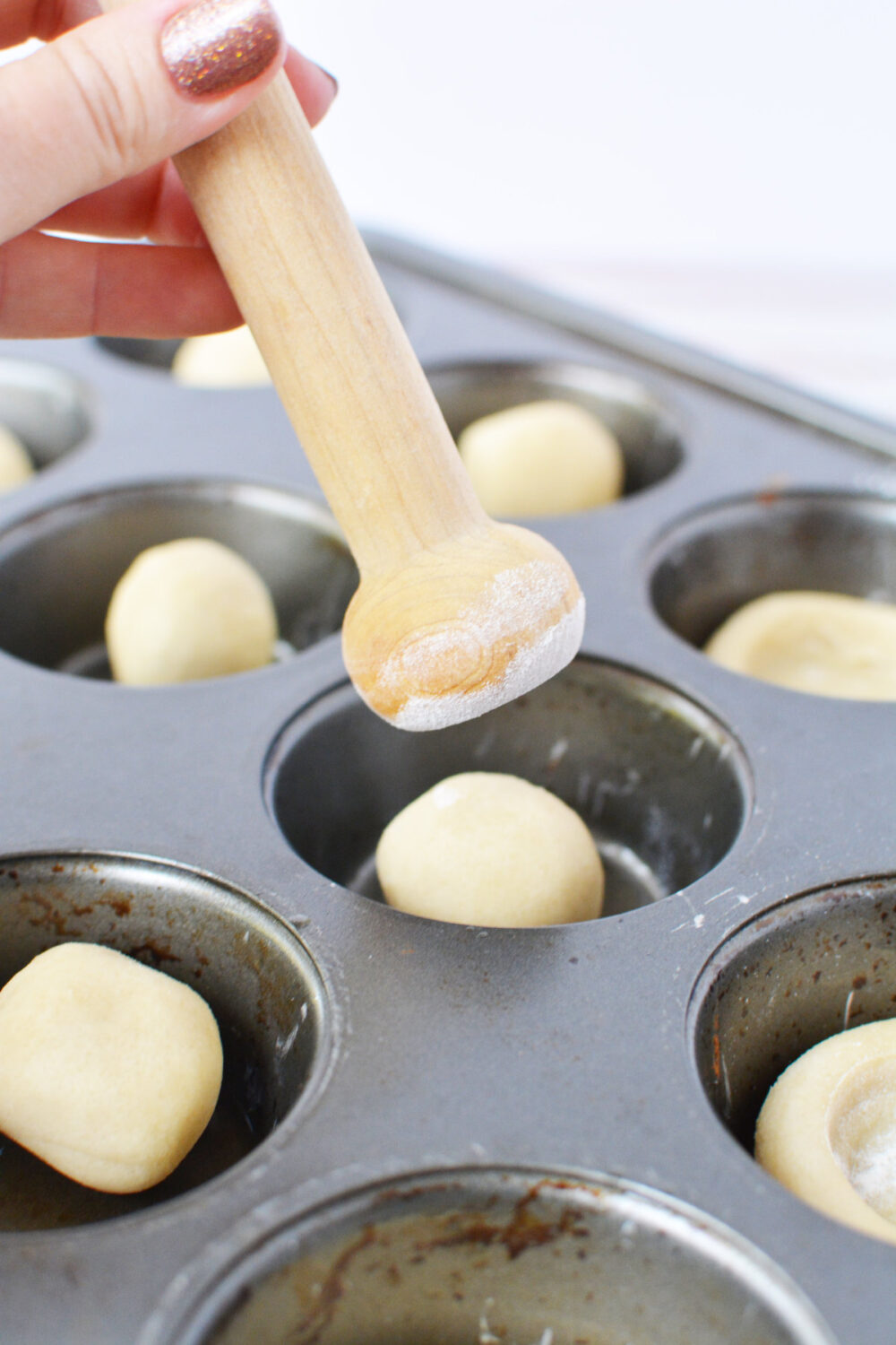 Using a tart shaper to shape dough. 