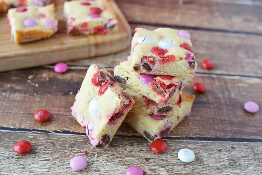 Sugar cookie bars stacked with Valentine's day candies. 