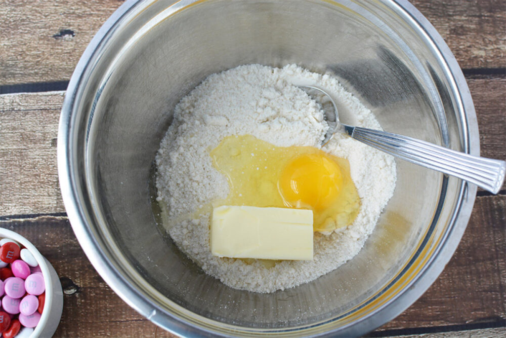 Sugar cookie mix, egg, and butter in a mixing bowl. 